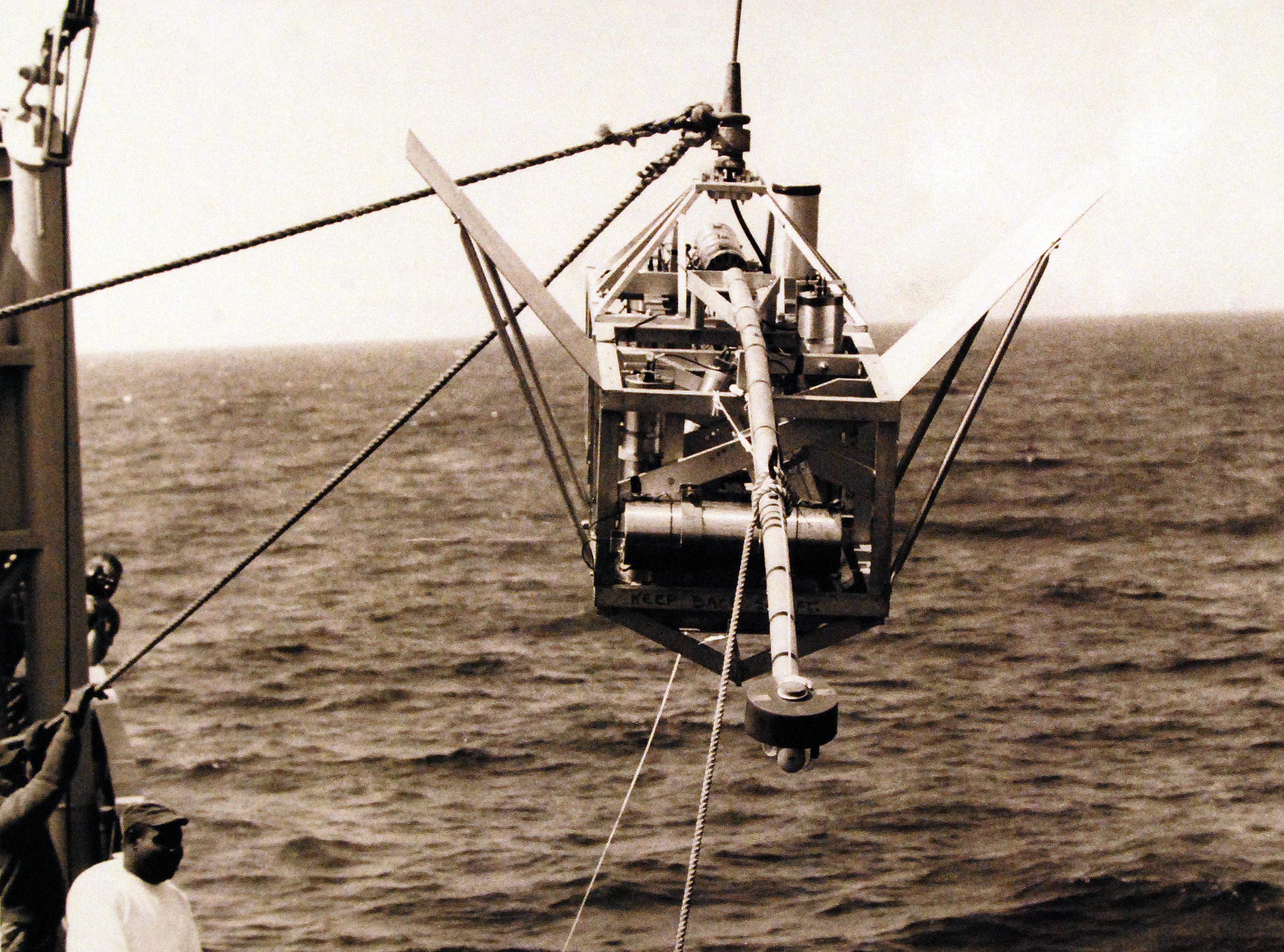Underwater camera device being lowered on a cable from a research ship, not a fish-finder display